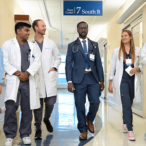 Residents walk with physician in hallway