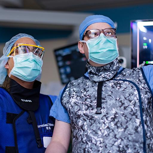 A group of doctors from the Interventional Advanced Diagnostic Pulmonary talk in an operating room.