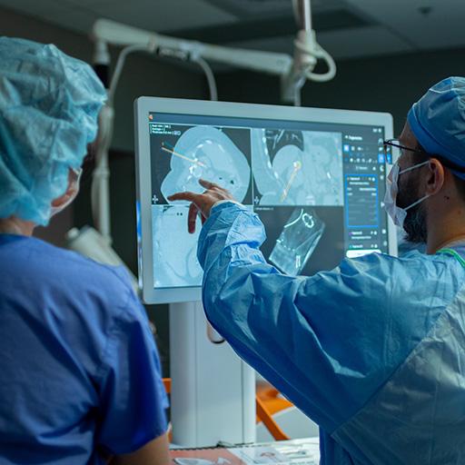 Two people in an operating room looking at a monitor.