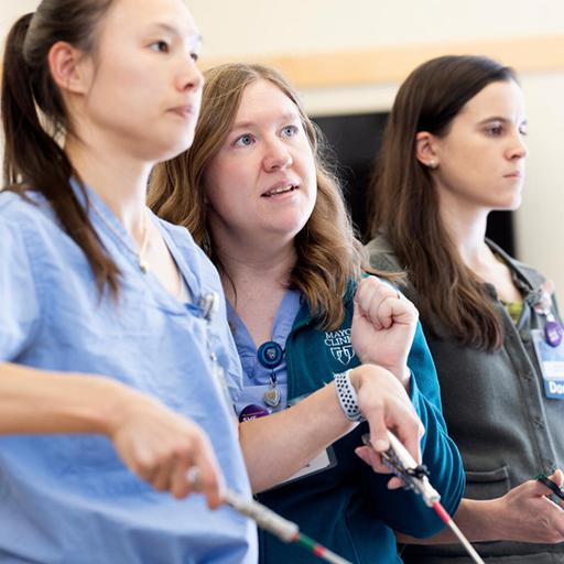 Adela Cope, Assistant Professor of Obstetrics and Gynecology, mentors residents in a laparoscopic simulation during a skills day session in the simulation center.