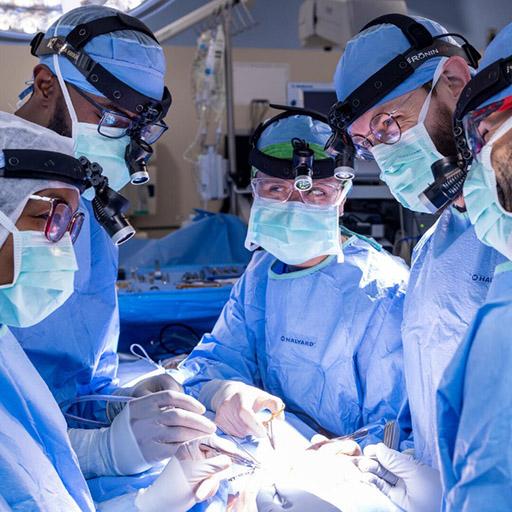 Five doctors perform a surgery in an operating room.