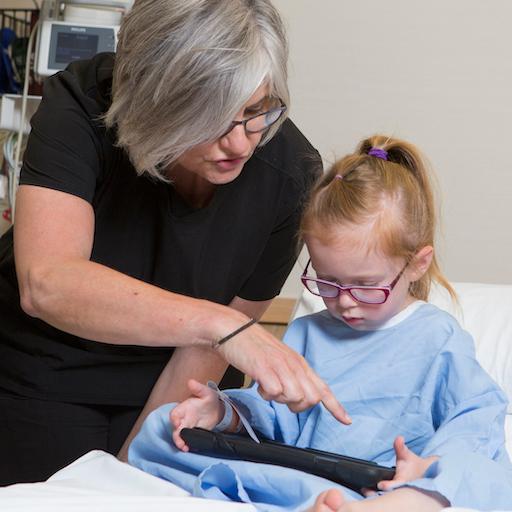A caregiver talks with a pediatric patient at Mayo Clinic.