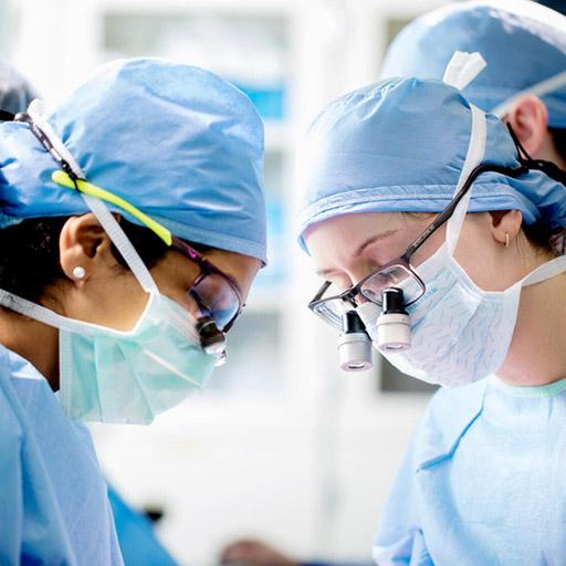 Close up of two doctors faces as they perform an operation.