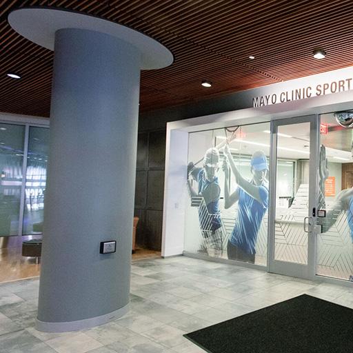 Glass wall mural of athlete images inside of Mayo Clinic Square building in Minneapolis, MN.