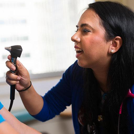 Pediatric and Adolescent Medicine resident examining a patient
