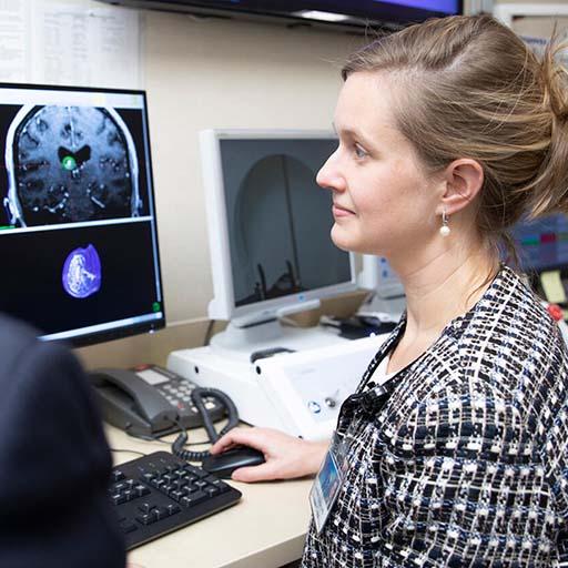 Radiation oncologists examine and discuss a scan on the computer