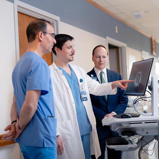 Walker Mangin, DO, MS, Pulmonary Disease Resident, reviews and discusses an image scan of lungs on a computer station with Joseph Skalksi, MD, and Robert Vassallo, MD, Pulmonary Consultants.