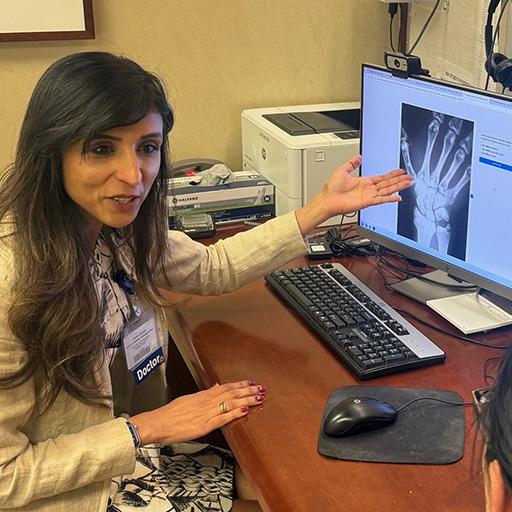 A doctors shows an xray of a hand to a patient.