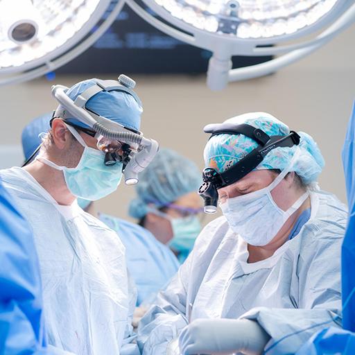 Boyd Viers, MD, PhD, Surgical Consultant in Urology, and surgical team members, wear loupe magnifiers and headlamp and focus toward the surgical field in the operating room.