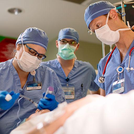 Anesthesiologists performing a procedure on a mannequin