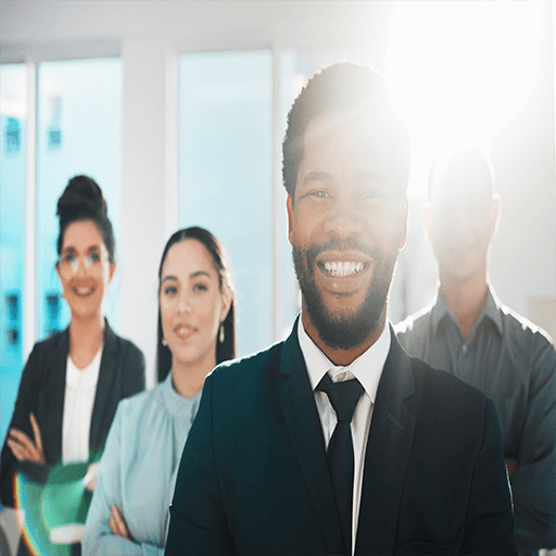 A group of professionals looking at a screen smiling with the bright son behind them.