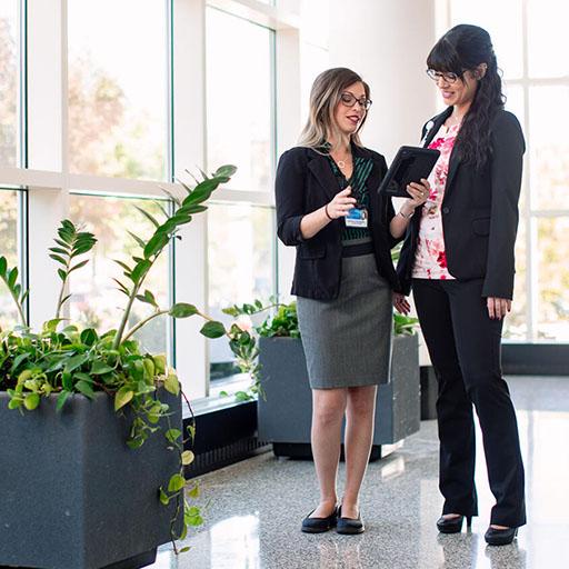 Two pharmacists consulting while walking down the hallway at Mayo Clinic