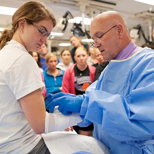 Students in the casting and suturing class working and with instructor