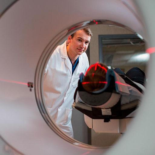 Student looking through positron emission tomography technology equipment