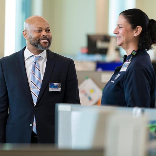 Mayo Clinic nurses and staff talk next to computers in the clinic lobby.