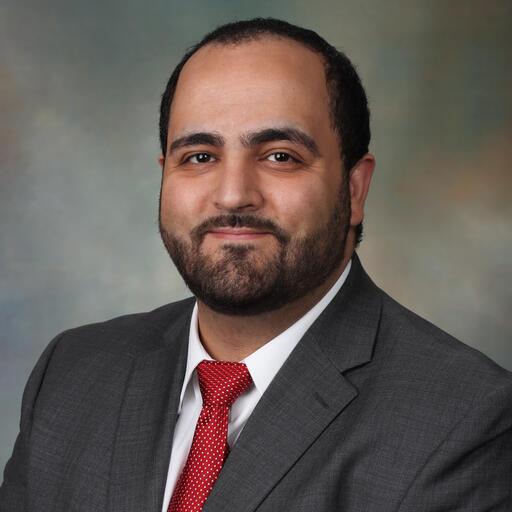 Profile of man wearing a suit, looking at camera