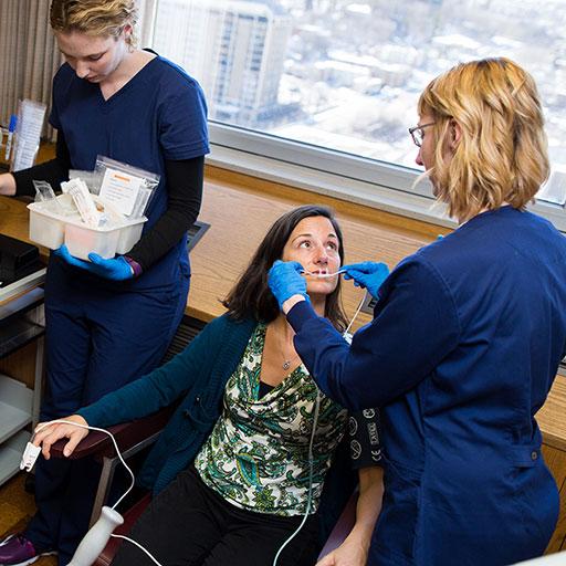 Allergy and immunology physicians and staff assist with a patient