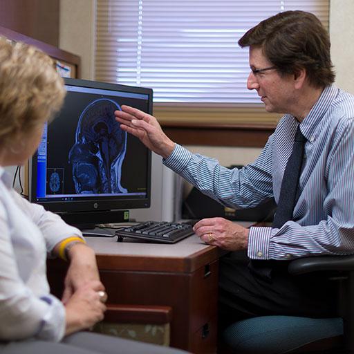 Neurologist examines a brain scan with a patient