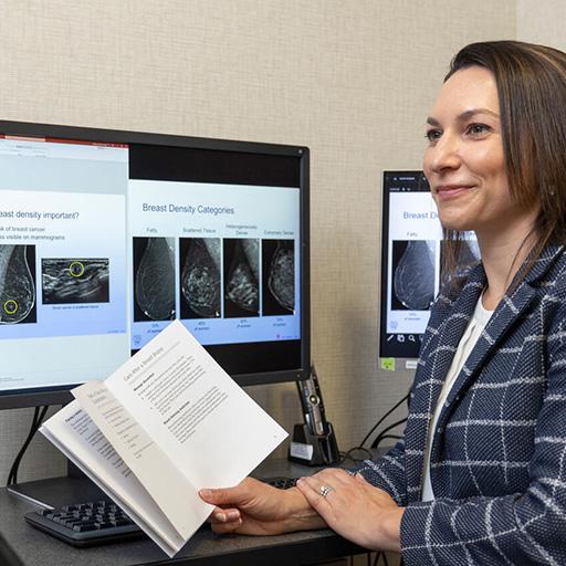 Kristin Robinson, MD, Diagnostic Radiology Consultant, reviews a pamphlet with a patient in an office.