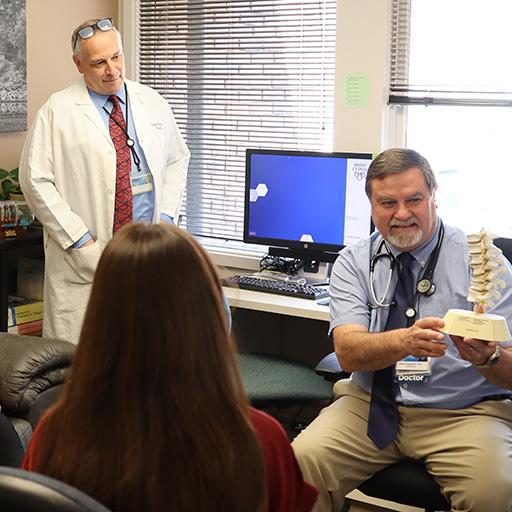 Students in patient room watching presentation with anatomic model.