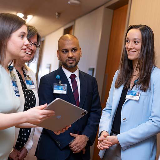 General Internal Medicine (GIM) staff collaborating on patient care in a corridor.