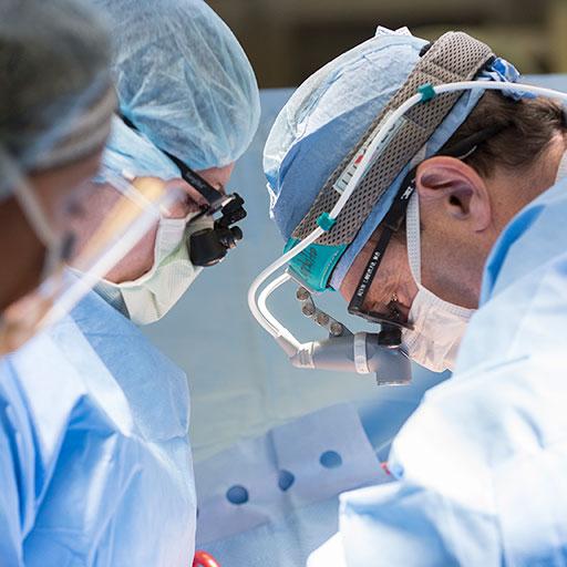Fellow assisting in a heart transplant in the operating room