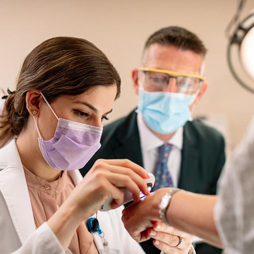 Two fellows examining hand