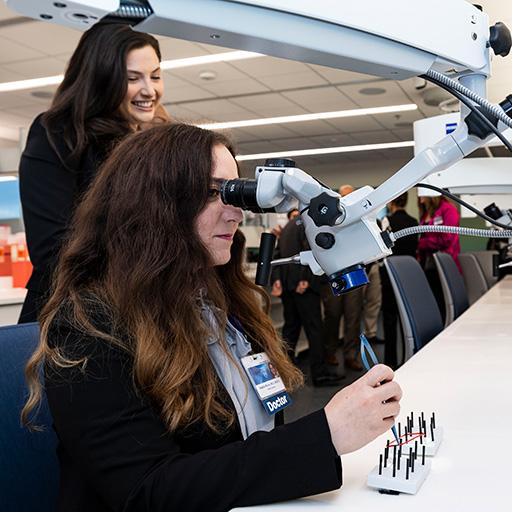 Two people from the Otolaryngology head and neck surgery residency looking through microscope