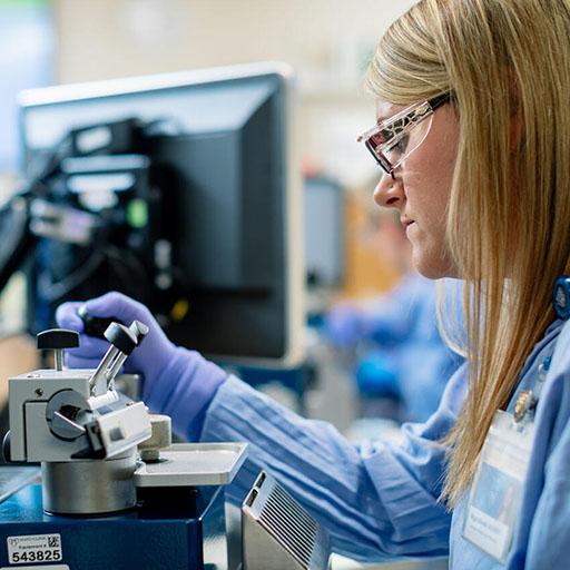 A resident in laboratory medicine and pathology examines specimens in the lab