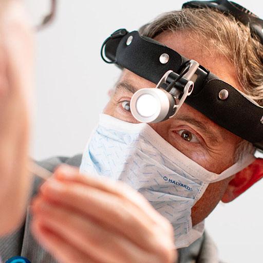 An Otolaryngology Head and Neck Surgery resident examines a patient's mouth and throat