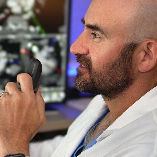 Radiology faculty examines scans while dictating his analysis