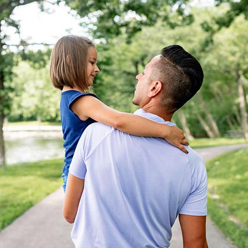 Father and daughter walk through a park in Rochester, Minnesota.