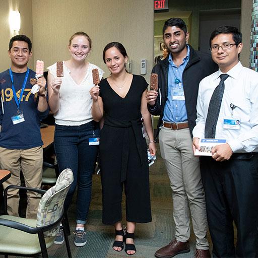Group photo of learners holding ice cream bars, smiling at camera