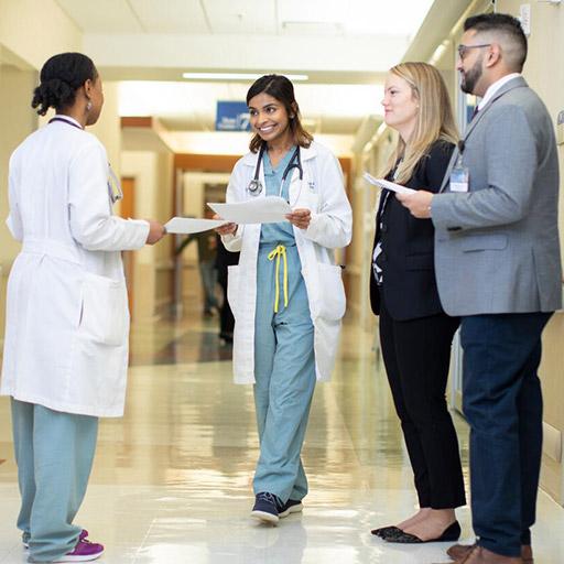 Group of consultant, nurse, and residents discussing case in hallway at Mayo Clinic.