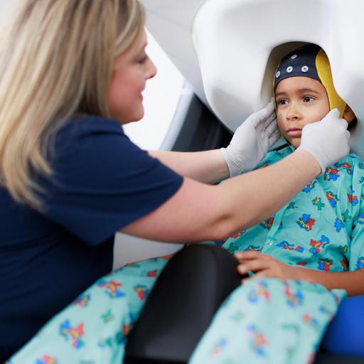 A doctor works with a child patient in an imaging machine.