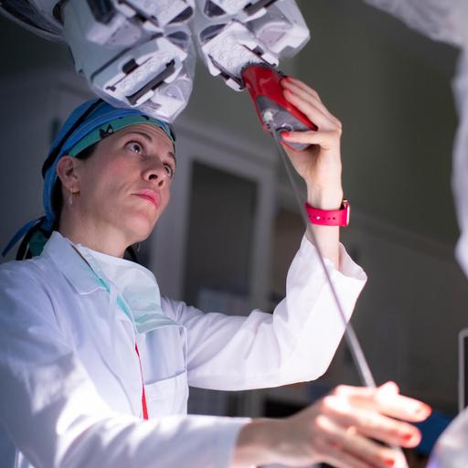 Katie Van Abel, MD, an otolaryngology surgeon, aligning and setting up trocar mounts on the patient-side cart prior to a robotic procedure.