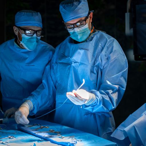 Two residents in operating suite looking at various surgical instruments.
