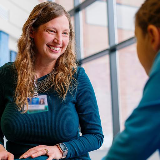Family Medicine nurse practitioner smiles and visits with a child patient at Mayo Clinic