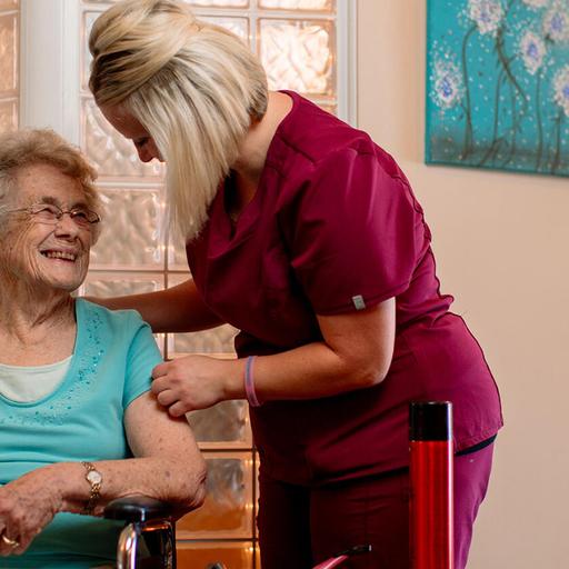 Nurse practitioner in hospice and palliative care assists an elderly woman in a wheelchair
