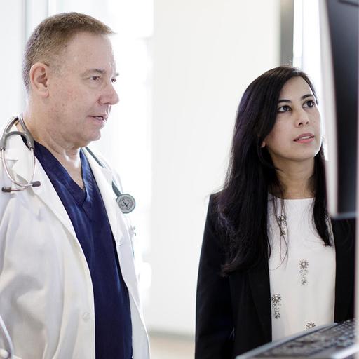 Nurse practitioners and physicians collaborate and review patient scans on a monitor
