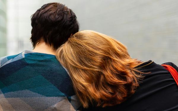 A person leaning their head on another person's shoulder