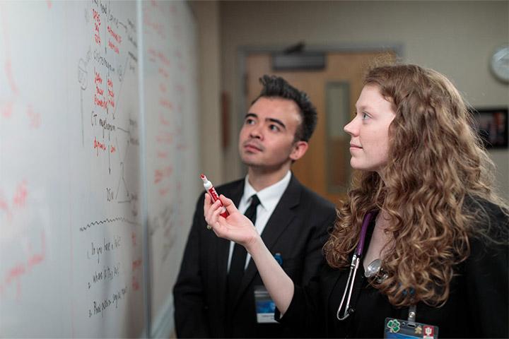Two Mayo Clinic employees collaborating next to a white board at Mayo Clinic in Rochester, Minnesota.