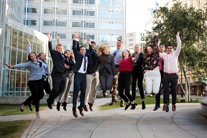 Trainees at Mayo Clinic take a group photo while jumping in the air outside at Mayo Clinic in Rochester, Minnesota.