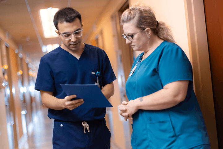 Two residents in hallway reviewing chart