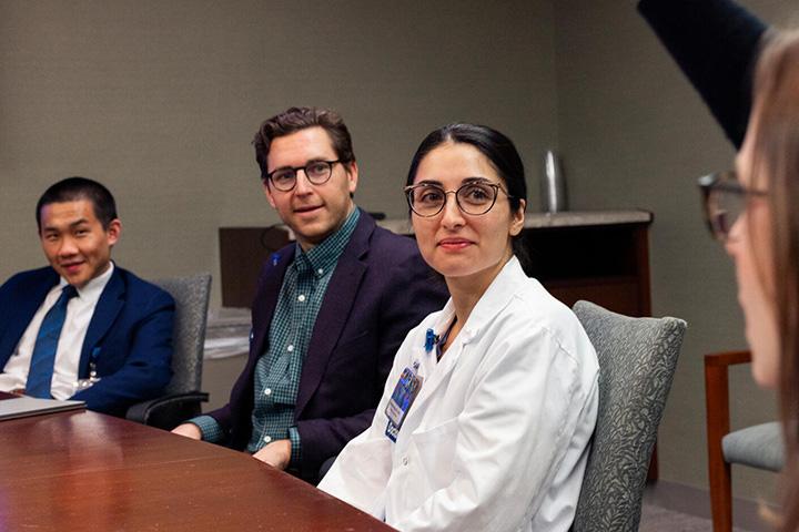 Three doctors sat around a table in a conference room having a discussion.