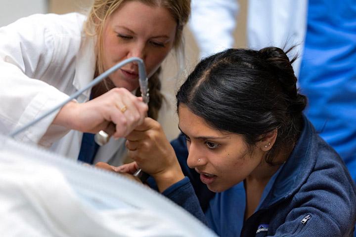 Two doctors work together with a scope during a medical procedure.
