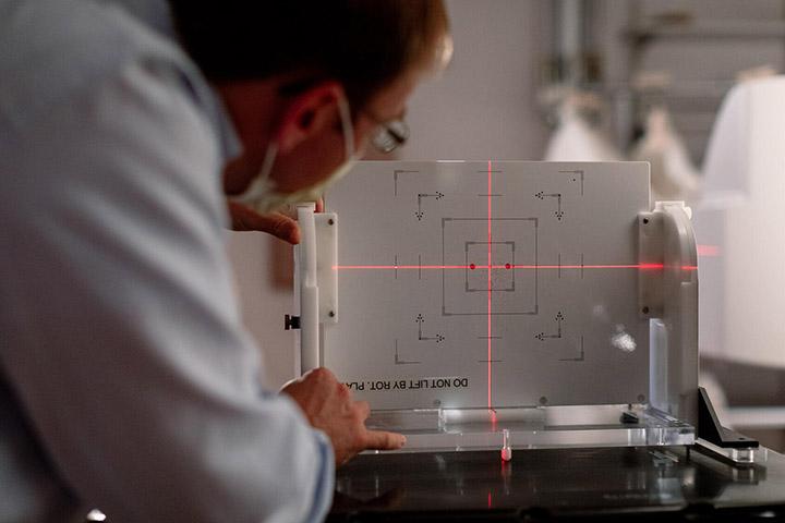 A medical professional sets up a laser beam for a patient procedure.
