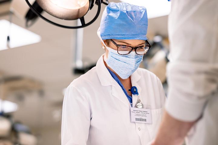 Katie Anderson instructs a resident in techniques during a procedure simulation