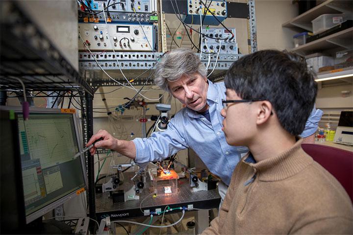 Faculty member helping student in a computer lab type setting
