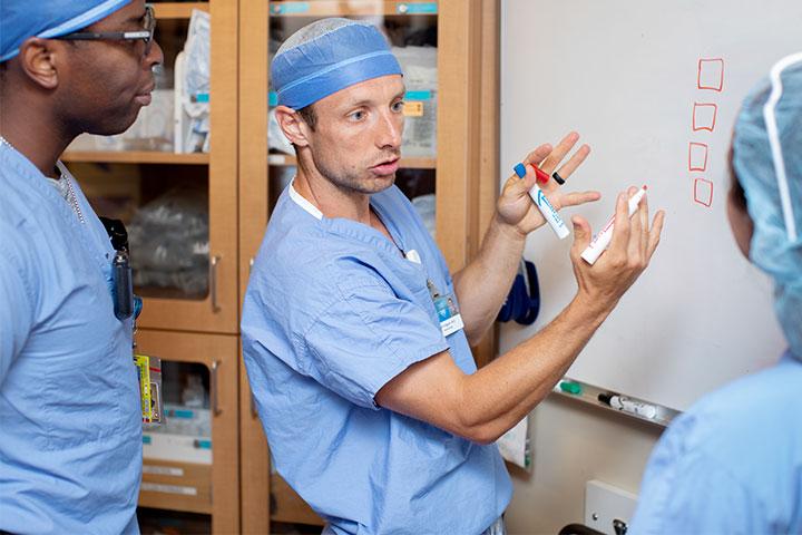 A faculty member explains a procedure to anesthesiology residents